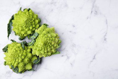 Beyaz mermer masa üzerinde taze Romanesco brokoli, düz. Metin için boşluk