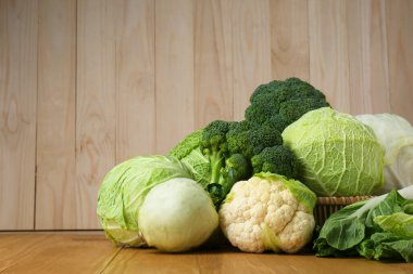 Ahşap masada bir sürü taze lahana çeşidi var. Metin için boşluk