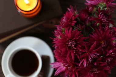 Güzel pembe kasımpatı çiçekleri ve ahşap masa üzerinde aromatik bir fincan çay ile kompozisyon, üst manzara. Metin için boşluk