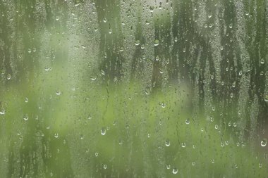 Arkaplan olarak yağmur damlaları olan pencere camları, yakın plan