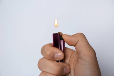Beyaz arka planda çakmak tutan adam, yakın plan