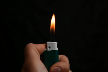 Siyah arka planda çakmak tutan kadın, yakın plan.