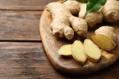 Kesilmiş ve taze zencefil ve ahşap masa, yakın çekim. Metin için boşluk