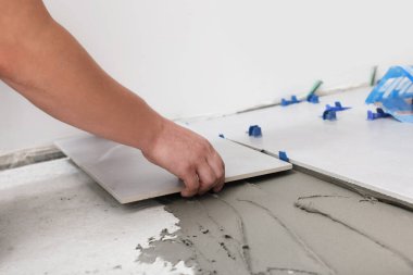 İşçi yere seramik fayans yerleştiriyor, yakın plan