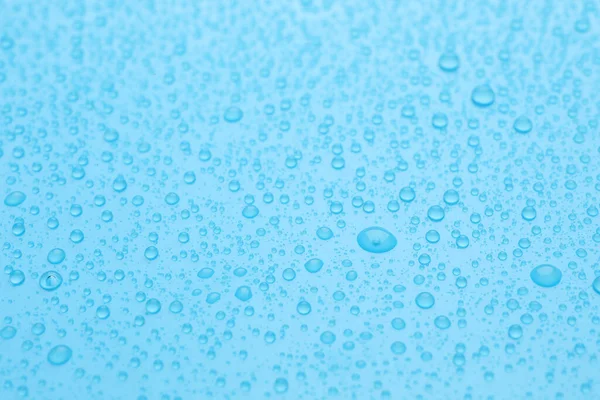 水は薄い青の背景に落ちます クローズアップビュー — ストック写真