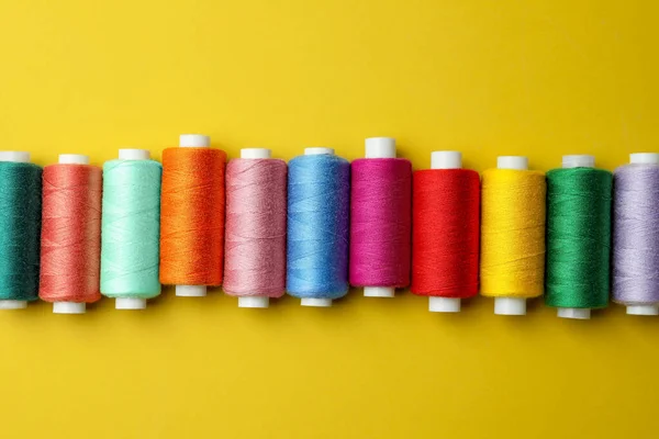 Set Fili Colorati Cucire Sfondo Giallo Posa Piatta — Foto Stock