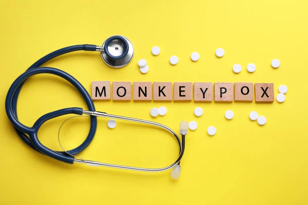 Word Monkeypox Valmistettu Puisia Kuutioita Pillereitä Stetoskooppi Keltaisella Pohjalla Tasainen — kuvapankkivalokuva