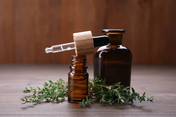 Natural thyme essential oil on wooden table