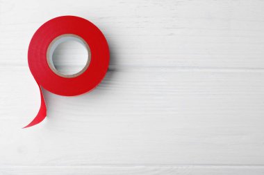 Beyaz ahşap masada kırmızı izolasyon bandı, üst manzara. Metin için boşluk