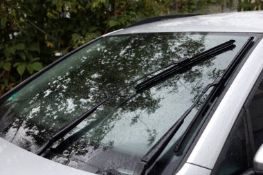 Arabanın ön camından yağmur damlalarını temizleyen silecekler.