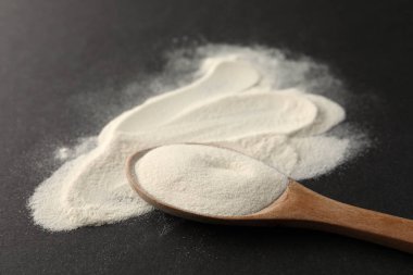 Siyah arkaplanda bir kaşık agar-agar tozu, yakın plan.