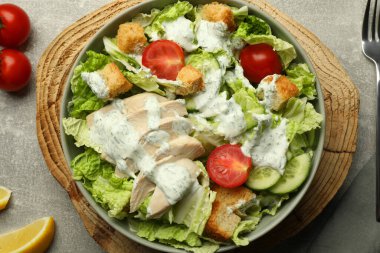 Çin lahanası, salatalık, et ve domatesli lezzetli salata gri masada servis edilir.