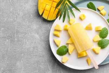 Gri masadaki mangolu lezzetli meyveli dondurma tabağı. Metin için boşluk