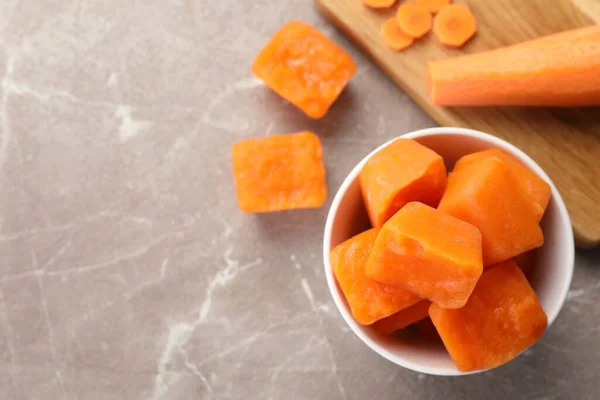 Schüssel Mit Gefrorenen Karottenwürfeln Und Zutat Auf Marmortisch Flach Gelegt — Stockfoto