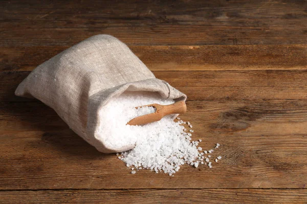 一袋天然海盐和勺子放在木制桌子上 案文的篇幅 — 图库照片