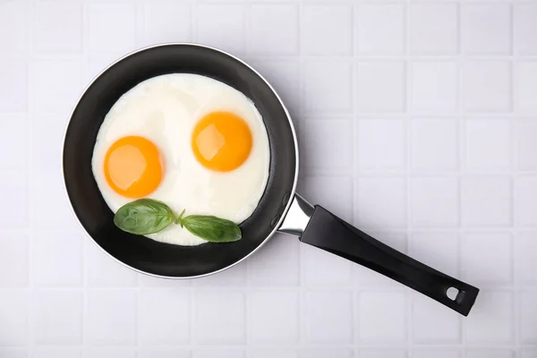 Вкусные Жареные Яйца Базиликом Кастрюле Белом Кафельном Столе Вид Сверху — стоковое фото