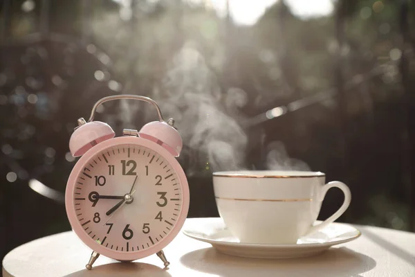 Relógio Alarme Rosa Xícara Com Bebida Quente Mesa Branca Manhã — Fotografia de Stock