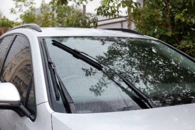 Arabanın ön camından yağmur damlalarını temizleyen silecekler.
