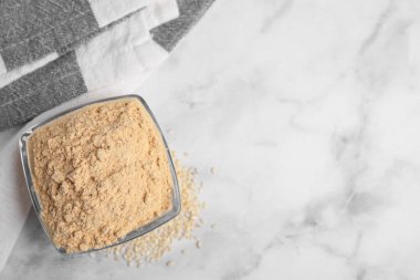 Cam kasede susam unu, beyaz mermer masa, üst manzara. Metin için boşluk