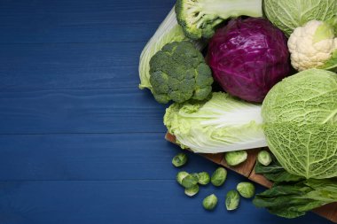 Mavi ahşap masada bir sürü taze lahanası olan bir tahta. Metin için boşluk