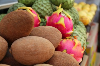 Cherimoya, sapodilla ve ejderha meyveleri markette tezgahta, yakın plan. Metin için boşluk