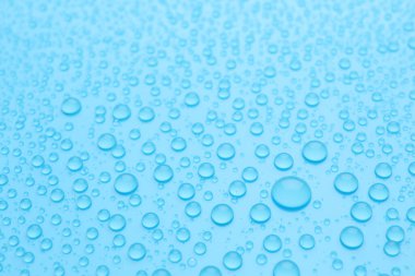 Açık mavi arkaplanda su damlaları, yakın plan görünümü