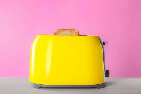 现代烤面包机 在白木桌上放有烤面包片 — 图库照片