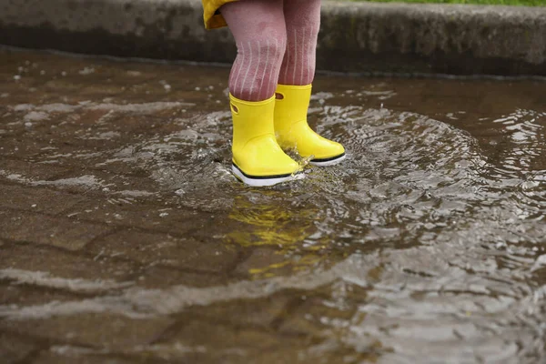 雨の日は屋外の水たまりの中を歩いている女の子 — ストック写真