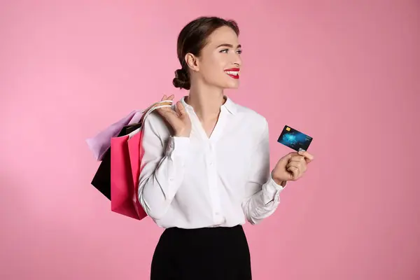 Glückliche Junge Frau Mit Einkaufstaschen Und Kreditkarte Auf Hellrosa Hintergrund — Stockfoto