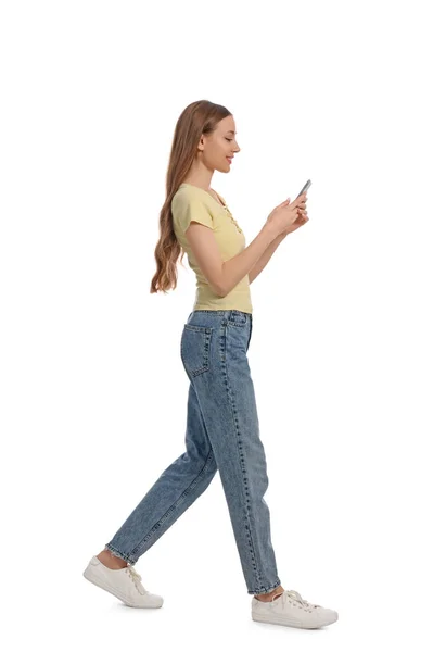 Mladá Žena Ležérní Oblečení Pomocí Smartphone Při Chůzi Bílém Pozadí — Stock fotografie