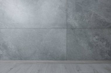 Temiz gri taş duvarlı boş bir oda.