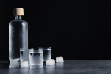 Siyah arka planda buzlu votka ve shot bardakları. Metin için boşluk