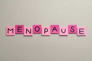 Kelime menopozlu pembe kağıt notlar bej arka planda, düz yatıyordu