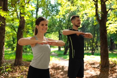 Erkek ve kadın parkta sabah egzersizi yapıyor.