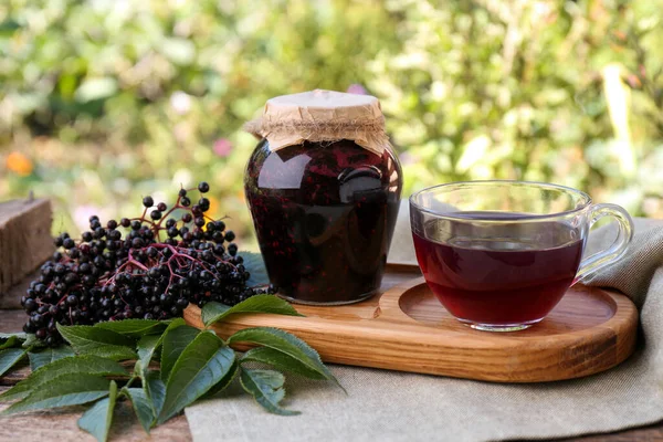 エルダーベリージャム 紅茶のグラスカップ 屋外のテーブルの上のサンブカスベリー — ストック写真