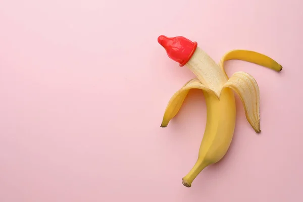 ピンクの背景にコンドームを持つバナナ トップビューとテキストのためのスペース 安全なセックスの概念 — ストック写真