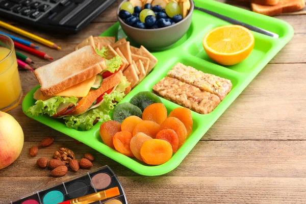 在木制桌子上放一盘子健康食品和文具 学校午餐 — 图库照片