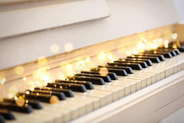 ピアノの鍵に妖精の光を投げ 閉じます クリスマス音楽 — ストック写真