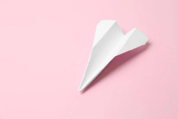 Handmade paper plane on pink background, space for text