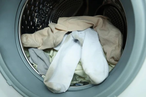 Many dirty socks in washing machine, closeup