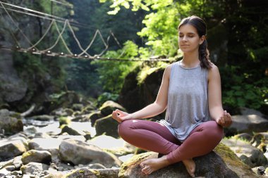 Dağlarda sabah egzersizi yapan güzel genç bir kadın.