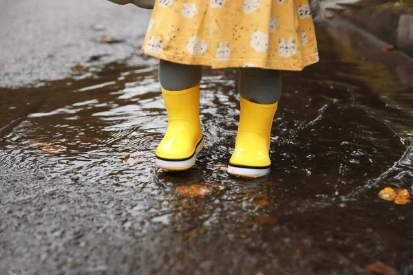 Sarı Lastik Botlar Giyen Küçük Bir Kız Birikintisinde Dikiliyor Yakın — Stok fotoğraf