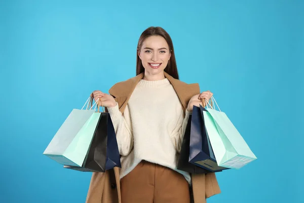 Glückliche Junge Frau Mit Einkaufstaschen Auf Hellblauem Hintergrund Großer Verkauf — Stockfoto