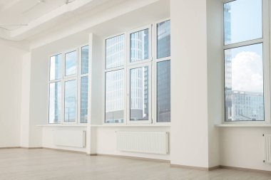 Beyaz duvarları ve pencereleri olan modern ofis odası. İç tasarım