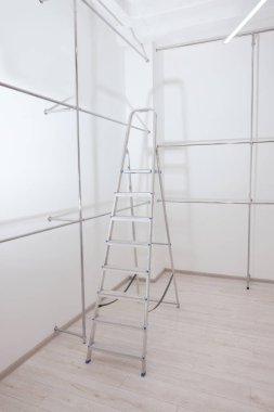 Boş yenilenmiş odada merdiven ve metal borular