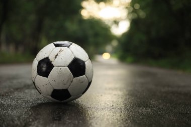 Islak yolda kirli deri futbol topu, mesaj için yer