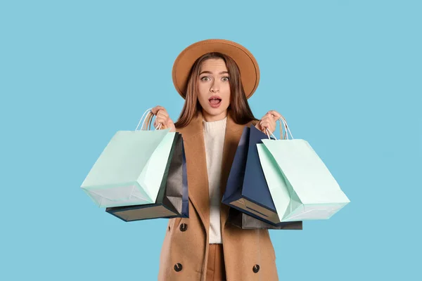 Überraschte Junge Frau Mit Einkaufstaschen Auf Hellblauem Hintergrund Großer Verkauf — Stockfoto