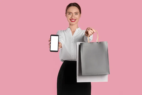 Glückliche Junge Frau Mit Einkaufstaschen Und Smartphone Vor Hellrosa Hintergrund — Stockfoto