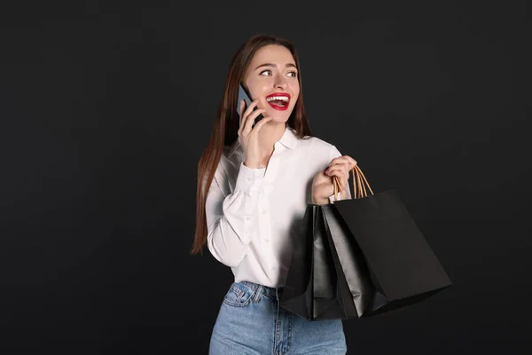 Boldog Fiatal Bevásárló Táskák Okostelefon Fekete Háttér Nagy Üzlet — Stock Fotó