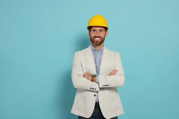 Professional engineer in hat on light blue background